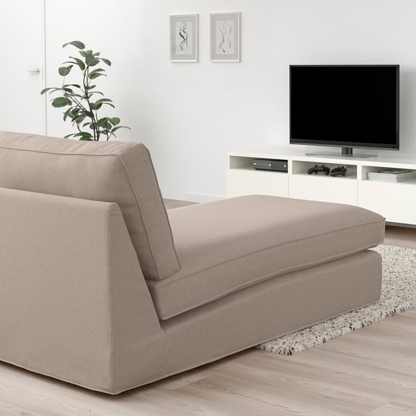 Salon moderne avec chaise KIVIK, télévision, accessoires de jeu, plante, art et tapis.
