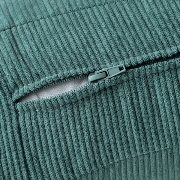 Tissu sarcelle avec texture côtelée et fermeture éclair, mettant en valeur des matériaux et un savoir-faire de haute qualité.
