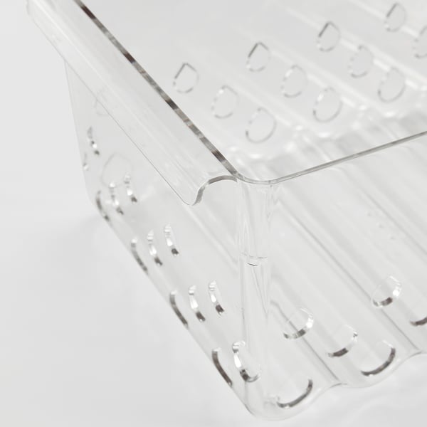 Panier de rangement en plastique transparent avec trous d’aération et poignées intégrées.