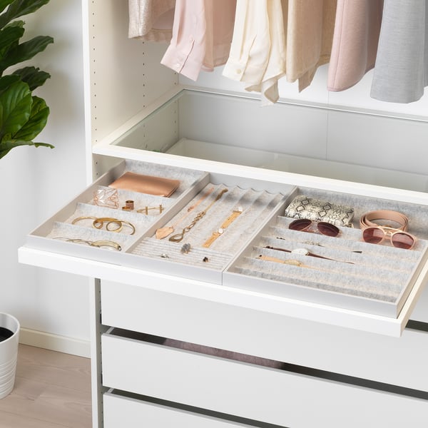 Un organisateur de tiroirs blanc avec des compartiments pour les bijoux et les accessoires. Le plateau se retire pour un accès facile et glisse silencieusement vers l’arrière.
