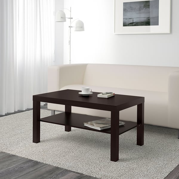 Table basse minimaliste avec étagère, contenant des tasses et des magazines dans un salon moderne.
