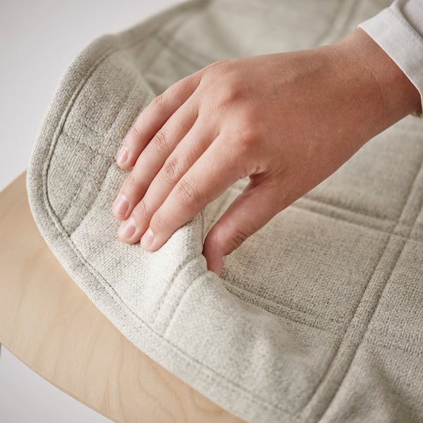 L’image représente une main testant le confort d’une chaise de conférence rembourrée, mettant en valeur son siège moelleux et confortable.