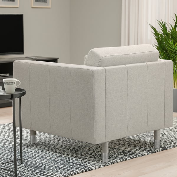 Fauteuil LANDSKRONA gris avec pieds en métal dans un salon moderne, table d’appoint près avec tasse, télévision et plante.
