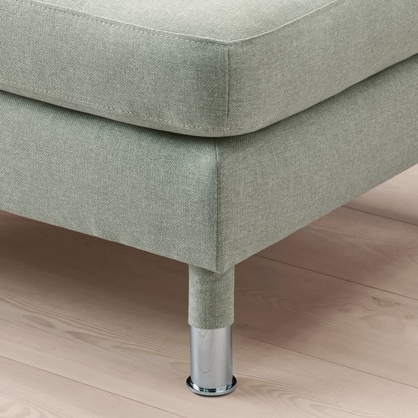 Gros plan d’un repose-pieds élégant et moderne avec des pieds chromés sur un plancher en bois.