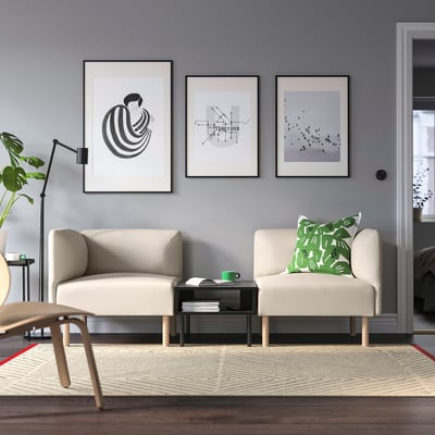 Salon moderne avec murs gris, lillehms, plante, art et tapis à motifs.