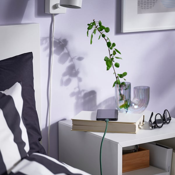 Configuration de chevet avec tablette, plante et câble USB.