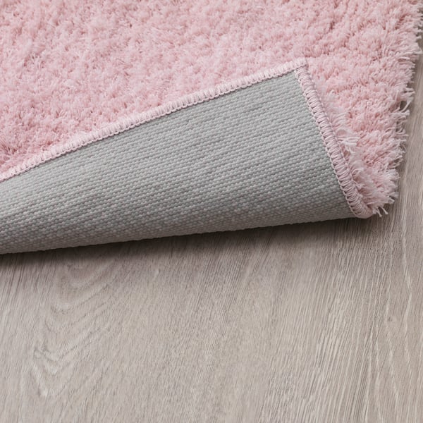 Gros plan de la capote et du dos gris texturé des tapis LINDKNUD roses, montrant sa peluche et son antidérapant.