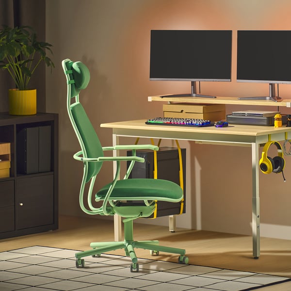 Configuration de jeu moderne avec chaise LÖPARBANA verte, deux moniteurs, clavier et écouteurs. La chaise est plus grande, avec un dossier haut et un appui-tête.