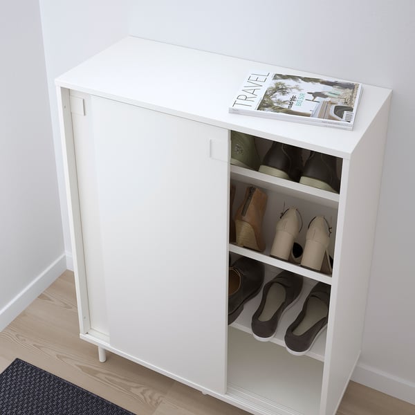 Armoire à chaussures blanche avec portes coulissantes, montrant les chaussures organisées à l’intérieur.