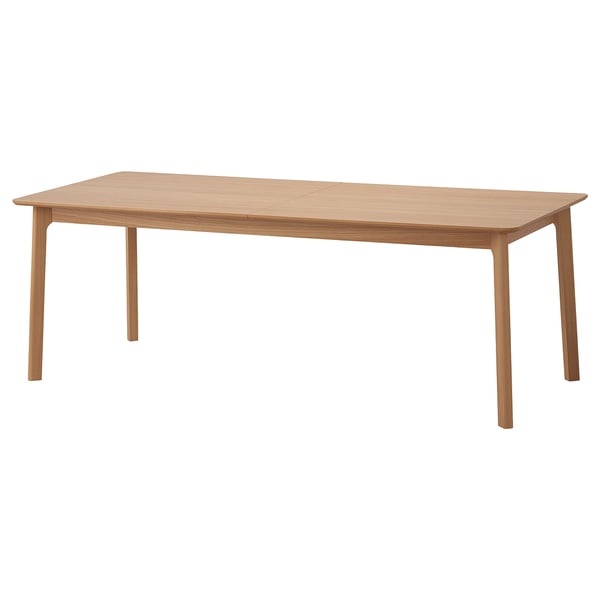 Une table à manger rectangulaire en bois clair aux lignes épurées et à la finition naturelle. Il a quatre pieds évasés et peut être étendu pour accueillir plus de personnes.