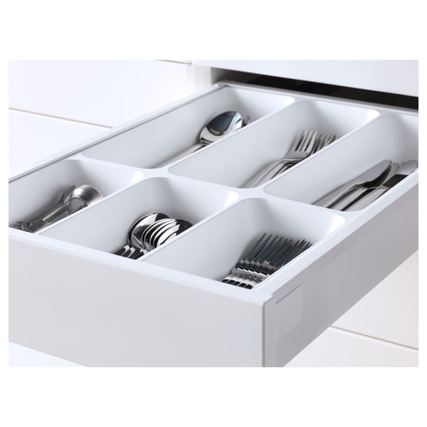 Organisateur de tiroir de cuisine blanc avec compartiments contenant des couverts. Faisant partie du système METOD, il s’agit de tiroirs à fermeture automatique et d’une garantie de 25 ans.