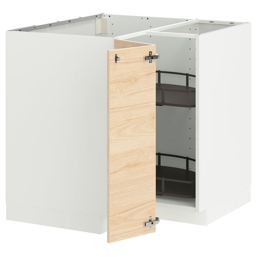 Un meuble de cuisine ikea METOD blanc avec une porte ouverte en bois de frêne clair, révélant des étagères noires réglables à l’intérieur.
