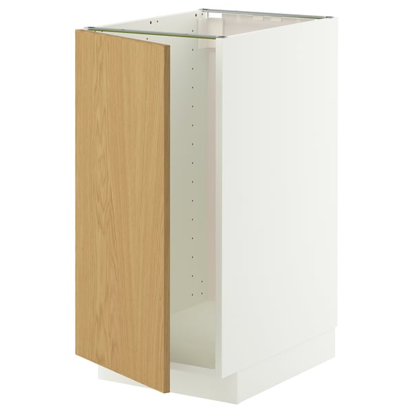 Un meuble de cuisine METOD blanc avec une porte en chêne clair et un cadre robuste. Il a un design moderne avec un look épuré et simple.