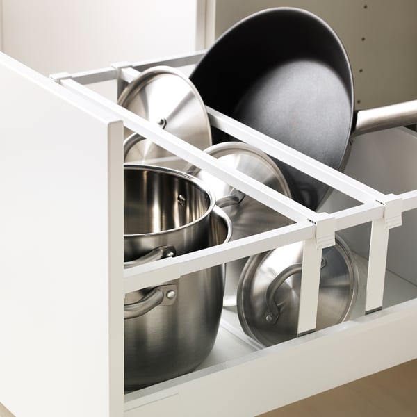 Tiroir de cuisine blanc stockant des casseroles et des poêles en métal, organisé avec des séparateurs, montrant un design moderne et épuré.