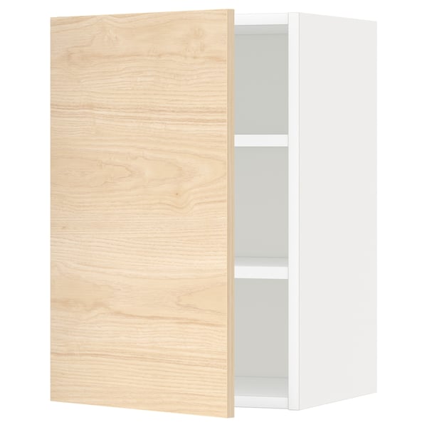 Une armoire murale de cuisine METOD blanche avec une porte en bois de frêne clair et une étagère réglable.