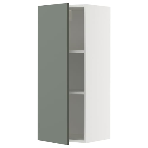 Une armoire murale METOD en blanc avec une porte gris-vert. Il a deux étagères à l’intérieur et est de conception moderne.