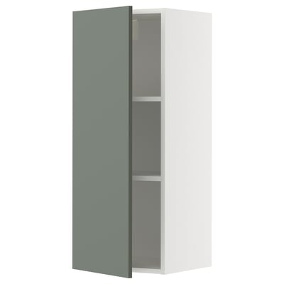 Une armoire murale METOD en blanc avec une porte gris-vert. Il a deux étagères à l’intérieur et est de conception moderne.