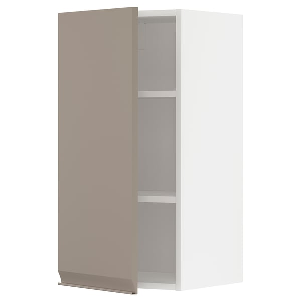 Une armoire de cuisine moderne, gris-beige, avec une finition mate et une poignée mince. Il dispose d’une étagère réglable à l’intérieur et d’un design minimaliste.