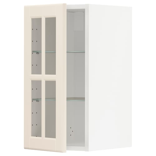 Un meuble de cuisine blanc METOD avec des étagères en verre réglables. L’armoire possède des portes en verre dépoli avec des bords biseautés, offrant un aspect traditionnel.