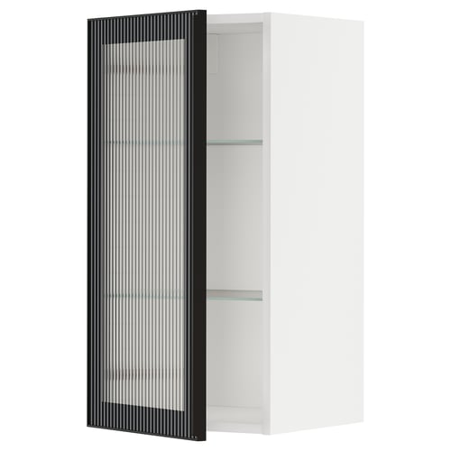 Il s’agit d’une armoire de cuisine METOD blanche avec une porte en verre hejsta noire avec du verre dépoli et un cadre métallique, offrant un aspect moderne.
