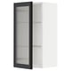 Il s’agit d’une armoire de cuisine METOD blanche avec une porte en verre hejsta noire avec du verre dépoli et un cadre métallique, offrant un aspect moderne.