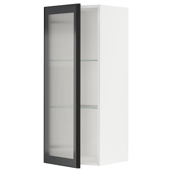 Présente une armoire de cuisine METOD blanche avec une porte en verre hejsta noir, avec un design en verre roseau et un cadre métallique élégant.