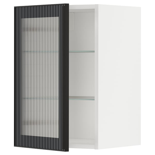 Un meuble de cuisine METOD blanc avec une porte en verre noir au motif cannelé. L’armoire dispose de deux étagères en verre.