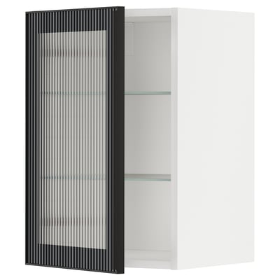 Un meuble de cuisine METOD blanc avec une porte en verre noir au motif cannelé. L’armoire dispose de deux étagères en verre.