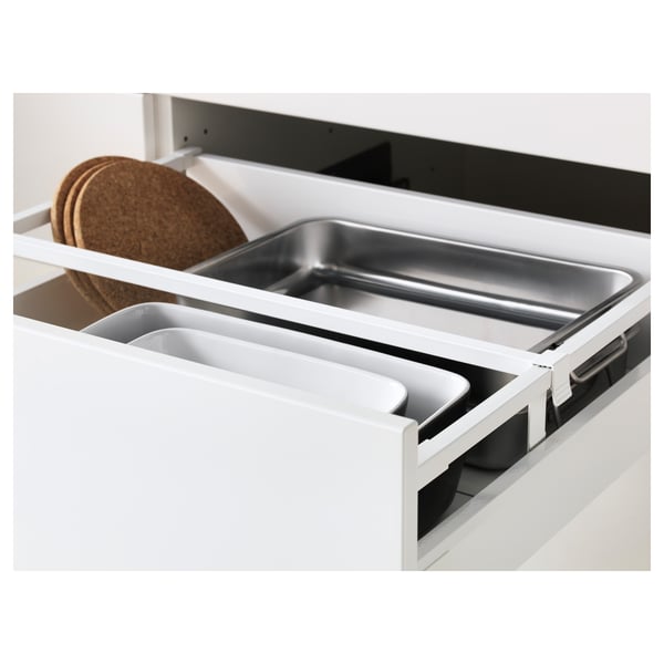 Tiroir de cuisine blanc avec plateau en métal et sous-verres en liège, faisant partie du système METOD.