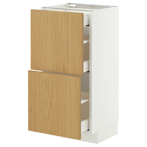 Une armoire de cuisine IKEA METOD avec des portes en bois clair et des côtés blancs. Il comprend plusieurs tiroirs et a un design moderne.