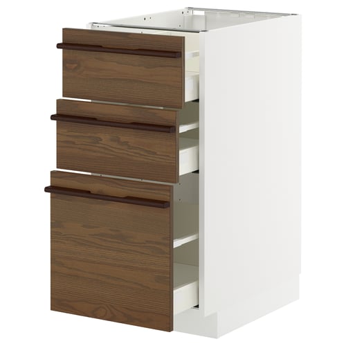 Une armoire de cuisine METOD blanche avec trois tiroirs en placage de frêne teinté brun foncé avec poignées en bois massif.