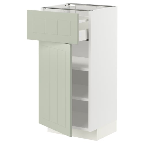 Une armoire de cuisine METOD blanche avec des portes et des étagères en stensund vert. Il a un design moderne et minimaliste avec un tiroir ouvert et une porte à charnières.