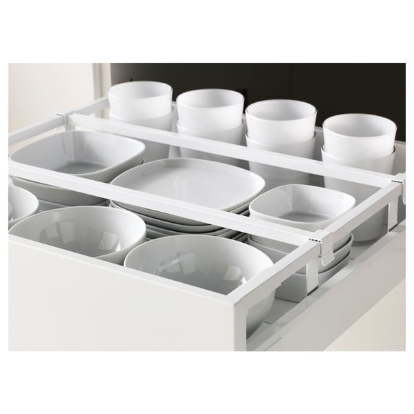 Organisateur de tiroir de cuisine blanc avec plusieurs compartiments pour assiettes et bols. Aide à garder les articles de cuisine propres et facilement accessibles.