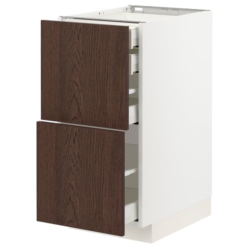 Une armoire de cuisine METOD blanche avec des façades de tiroir en sinarp brun foncé. Il dispose de plusieurs tiroirs de forme rectangulaire.