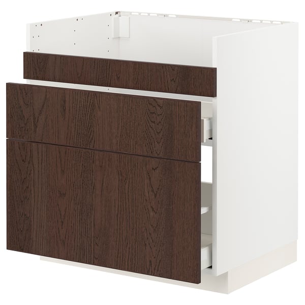 Armoire de cuisine en bois blanc et foncé avec trois tiroirs et étagère.