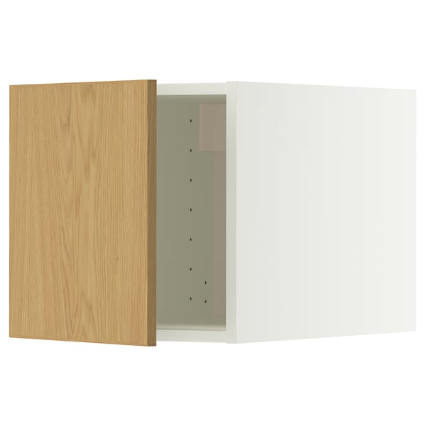 Une armoire de cuisine blanche avec une porte en bois. La porte a des charnières et est ouverte, révélant l’intérieur.