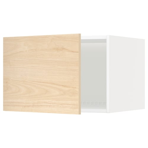 Un meuble de cuisine METOD avec une porte askersund en bois de frêne clair. Il a un cadre blanc et une porte en bois légèrement entrouverte.