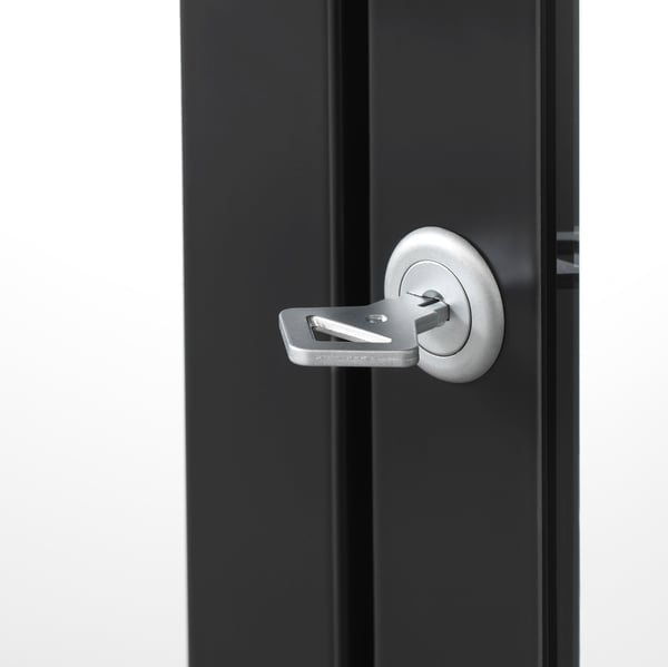 Une élégante armoire noire à portes vitrées MILSBO, dotée d’une poignée argentée moderne et d’une serrure pour un rangement sécurisé.