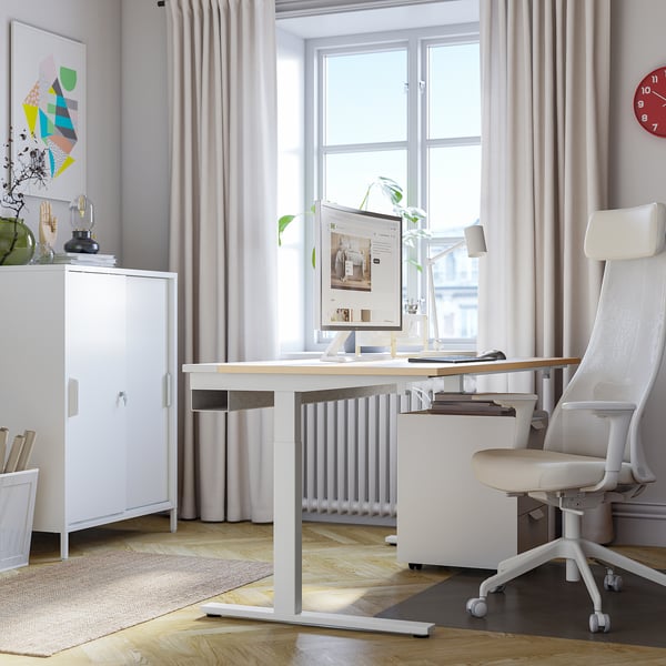 Bureau à domicile moderne : bureau MITTZON blanc, chaise ergonomique, moniteur, objets décoratifs. Propre, bien éclairé, spacieux.