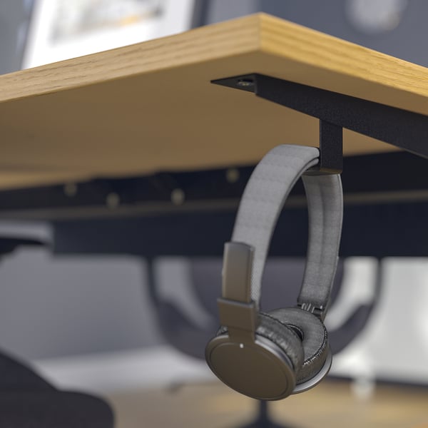 Bureau MITTZON réglable en hauteur avec crochets pour écouteurs et gestion des câbles pour une utilisation ergonomique au bureau.