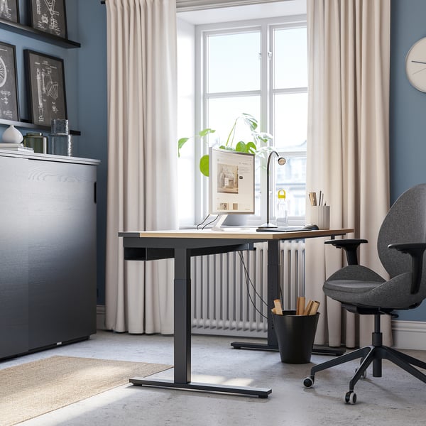 Configuration du bureau à domicile avec bureau réglable en hauteur MITTZON , chaise grise et fenêtre ; Soigné et organisé.