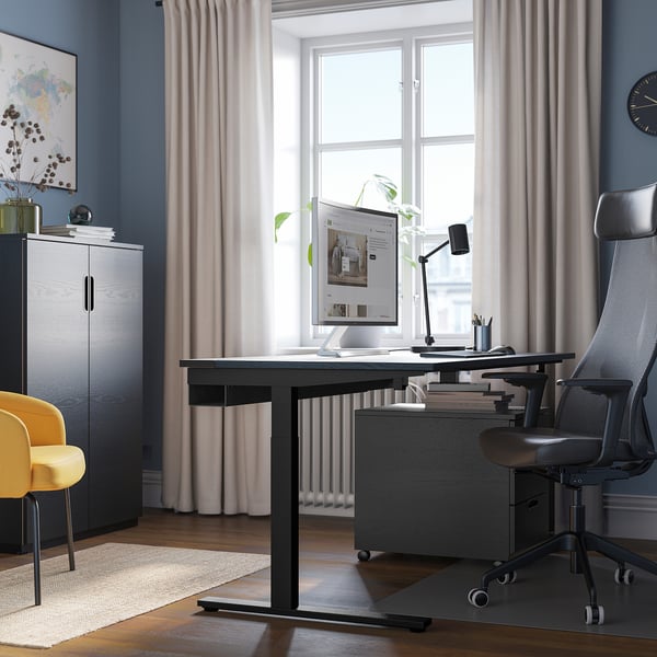 Bureau à domicile : bureau MITZZON, chaise grise, fenêtre, accent jaune, rangement avec plante et carte.