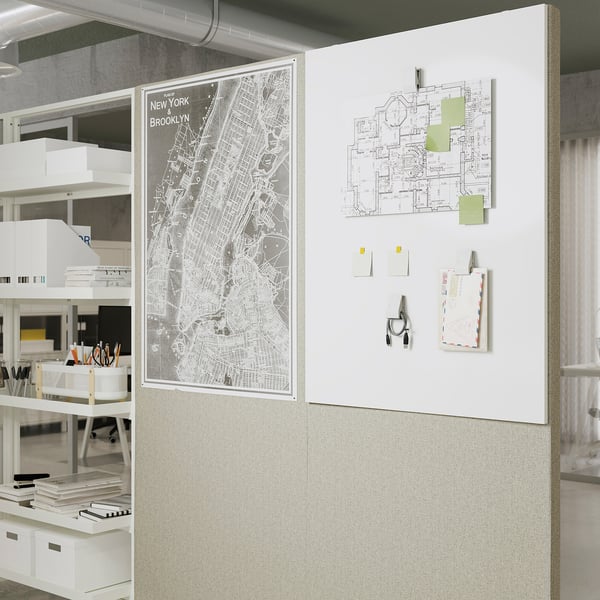 Une configuration de bureau avec un tableau mural en liège sur lequel sont épinglées diverses notes et cartes.