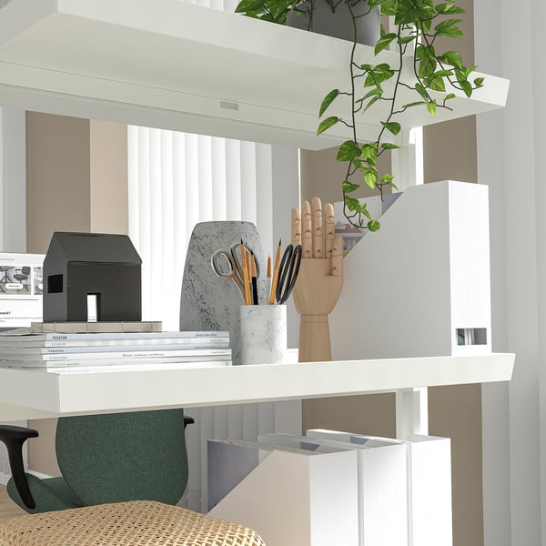 Un système moderne de division des bureaux avec des étagères exposant des livres, une main en bois et des plantes ; portable avec roulettes.