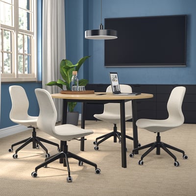 Table de conférence MITTZON avec chaises blanches dans un espace de travail confortable avec télévision et fenêtre.