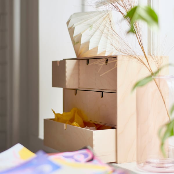 Mini commode en bois MOPPE avec tiroirs près de la fenêtre, organisant les petits objets.