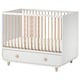 Un lit bébé MYLLRA blanc et bois clair avec un tiroir pour une chambre de bébé.