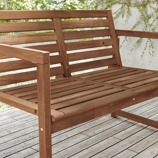 Banc d’extérieur en bois marron, fait partie de la série ikeas NÄMMARÖ. Fabriqué en bois d’acacia robuste avec une conception à lattes pour la ventilation.