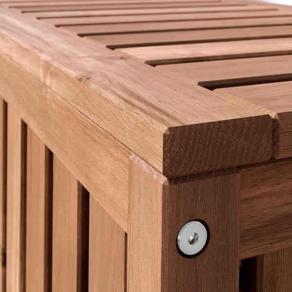 La boîte de rangement extérieure NÄMMARÖ en bois d’acacia avec couvercle à lattes.