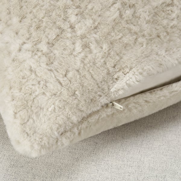 Gros plan de la taie d’oreiller beige douce et moelleuse avec fermeture éclair visible, mettant en valeur sa texture et sa qualité super douces.